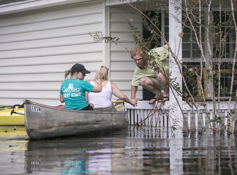 Image: David Covington jumps from a porch railing to his canoe in Conway, South Carolina