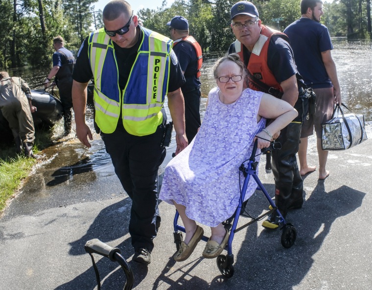 Image: Coastguardsmen and Conway Police help Denise Fulmer from her flooded home