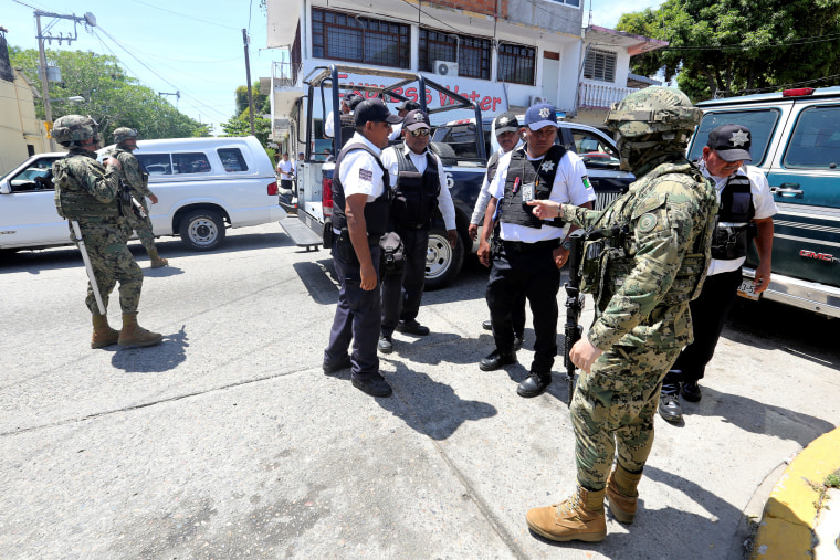 Mexican Marines escort municipal police officers disarmed and detained during an operation to check if they colluded with organised crime, in Acapulco