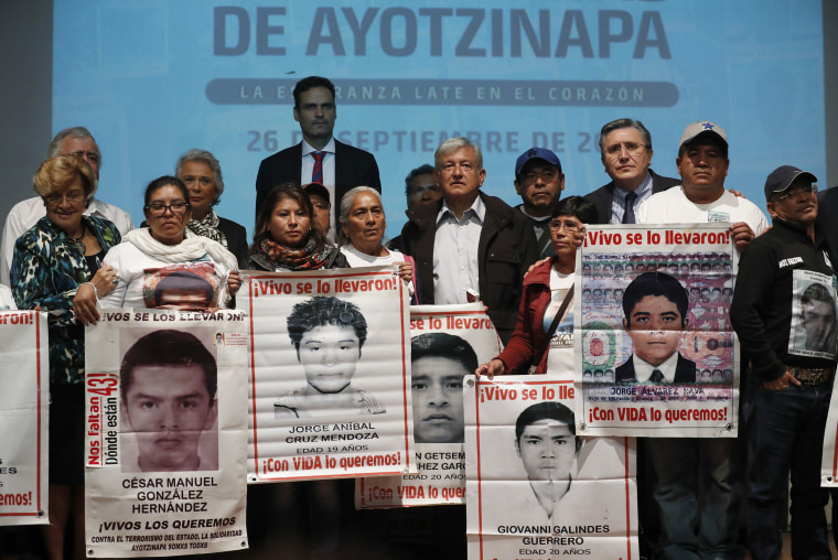 President-elect Andres Manuel Lopez Obrador, center, poses with the relatives of some the 43 college students who disappeared