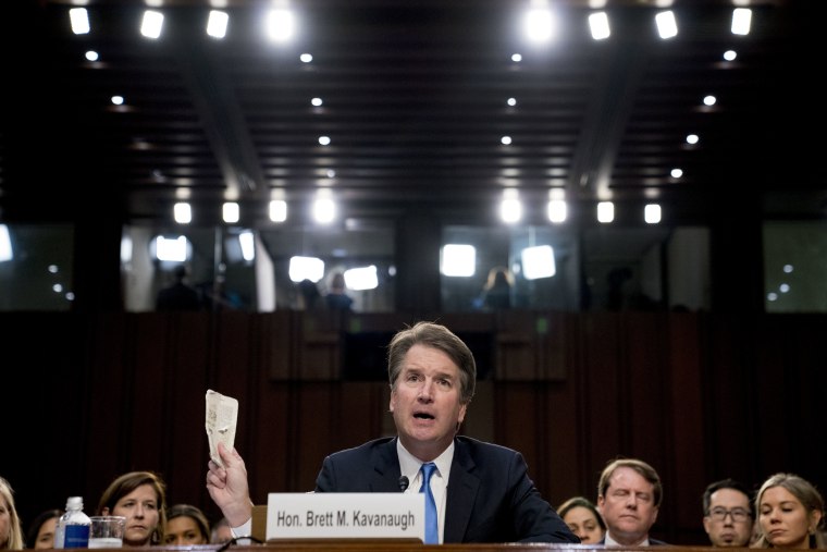 Image: Kavanaugh holds up a worn copy of the Constitution of the United States
