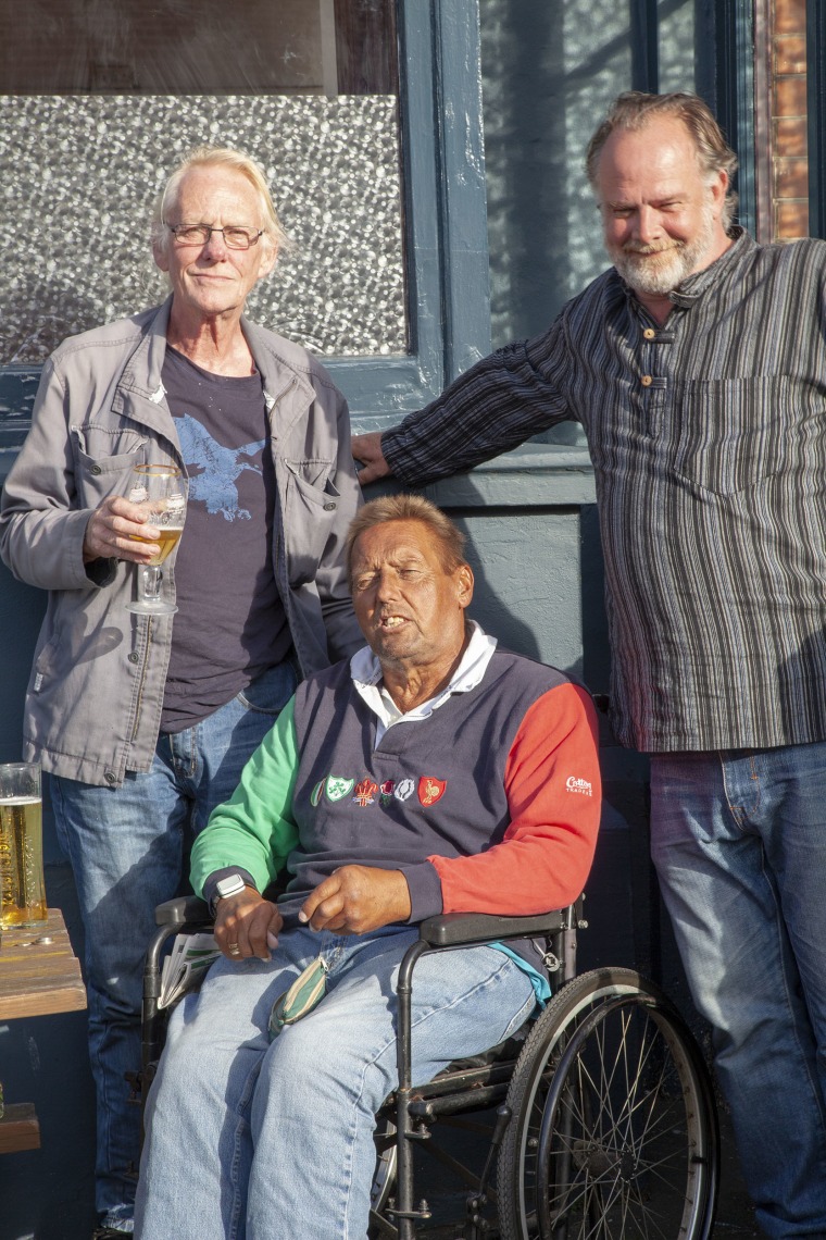 Image: Cab driver Michael Dow (left) drinks with friends at a pub in Margate, England