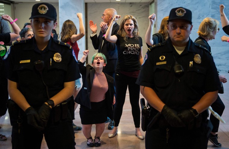 Police look on as protesters are arrested in the Hart Senate Office Building during a rally against Supreme Court nominee Brett Kavanaugh on Capitol Hill on Oct. 4, 2018.