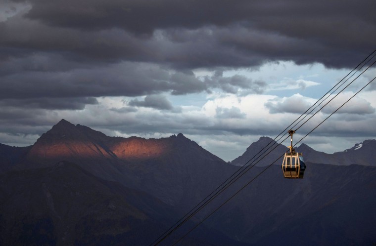 Image: A cable car is pictured with Caucasus mountains during sunset in the background outside Krasnaya Polyana near Sochi