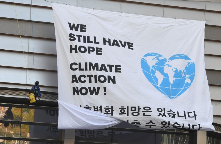 Image: Greenpeace activists display a big banner reading "We still have hope, Climate action now!"