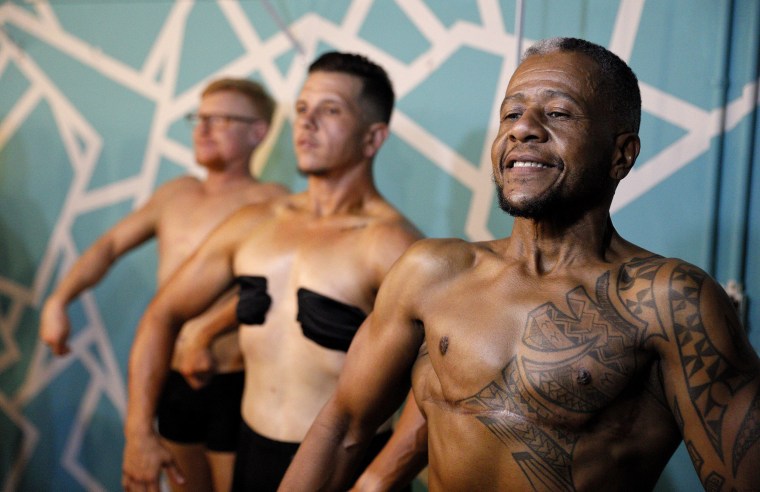 Image: Charles Bennett, from right, of San Francisco, practices a pose in front of a mirror with fellow contestants Devyn Michael Clark, of Jacksonville, Fla., and Peter Moore, of Oakland, Calif., backstage before the start of the International Associatio