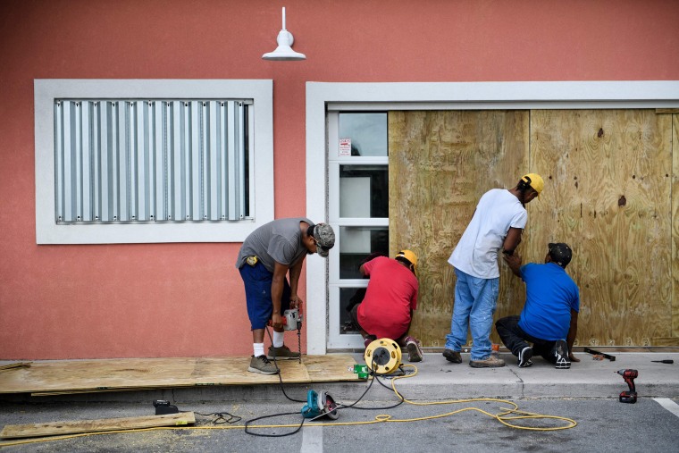 Workers board the windows of Marco's Pizza in Panama City Beach, Florida, as Hurricane Michael approaches on Oct. 9, 2018 .
