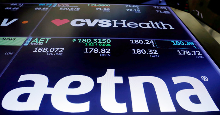 Image: FILE PHOTO: Logos of CVS and Aetna are displayed on a monitor above the floor of the New York Stock Exchange shortly after the opening bell in New York