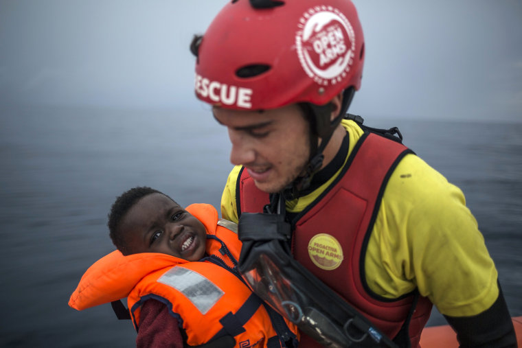 A member of Spanish NGO Pro activa Open Arms holds a baby rescued at a dinghy at Alboran Sea