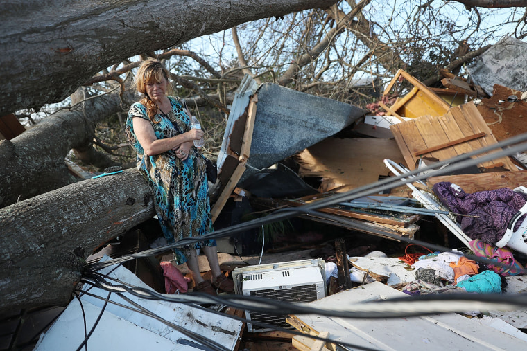Kathy Coy stands among what is left of her home after Hurricane Michael destroyed it