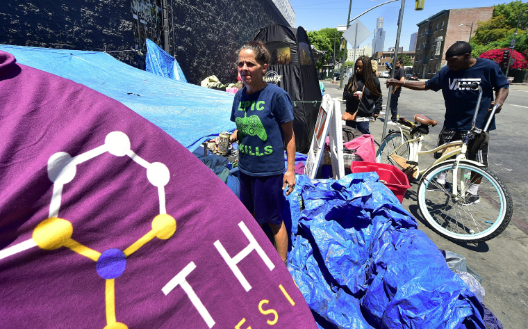 Homeless since August 2016, Tina Marie Van Tasil holds a can of beer while standing in front of her tent near Skid Row in downtown Los Angeles on June 20, 2017.