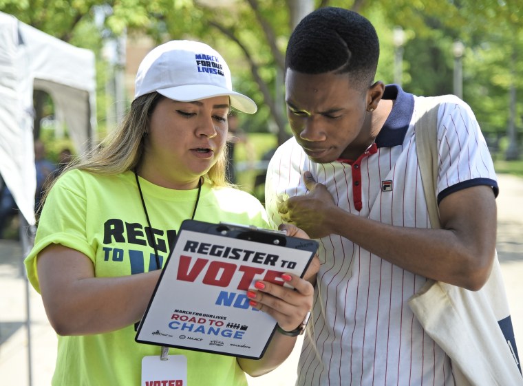 Ana Licona, left, helps Gregory Williams register to vote on June 16, 2018, in Chicago.