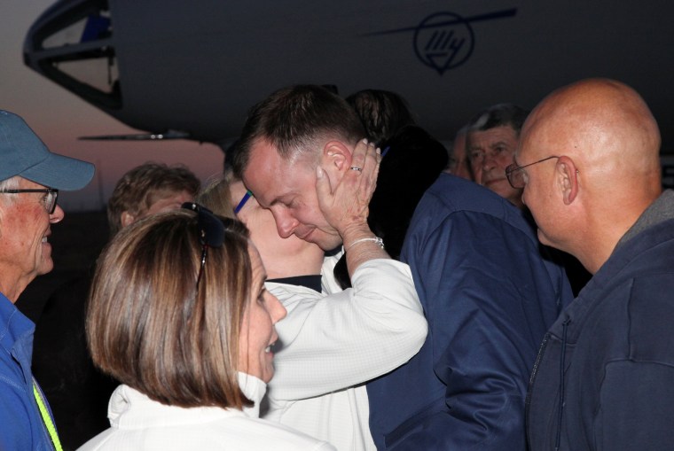 Nick Hague greets family members upon the arrival at Baikonur airport