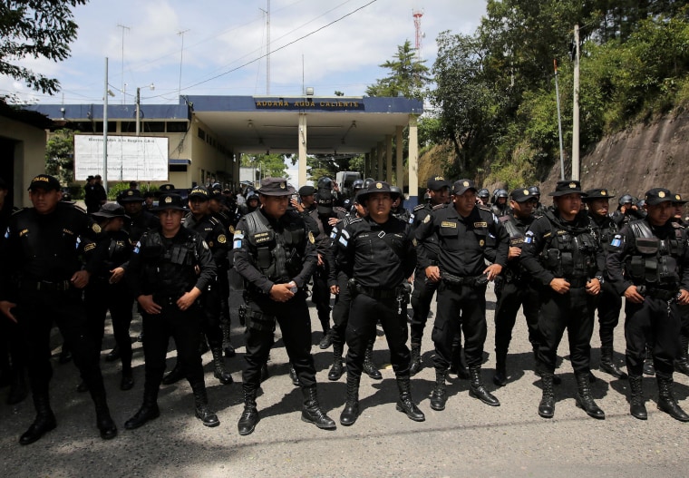 Guatemala's police officers stand as Honduran migrants, part of a caravan trying to reach the U.S.,