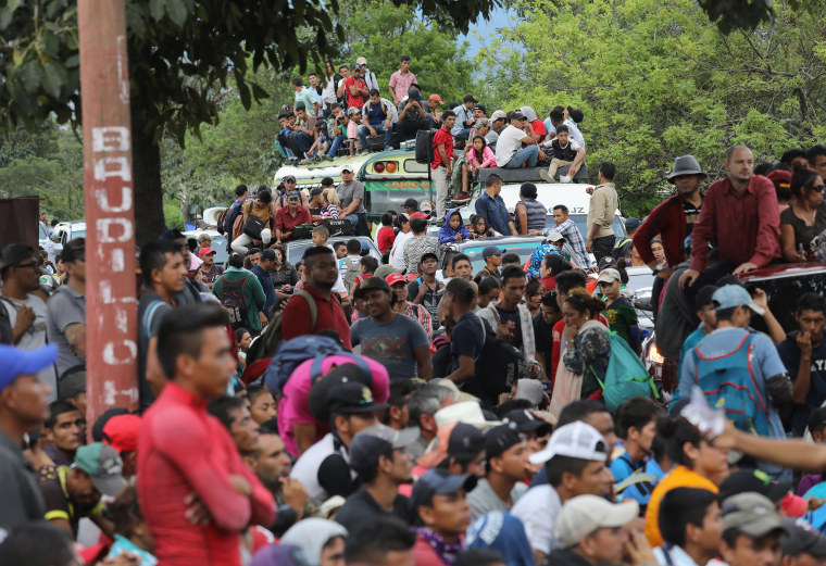 A caravan of more than 1,500 Honduran migrants pause after crossing into Guatemala on Oct. 15 in Esquipulas, Guatemala.