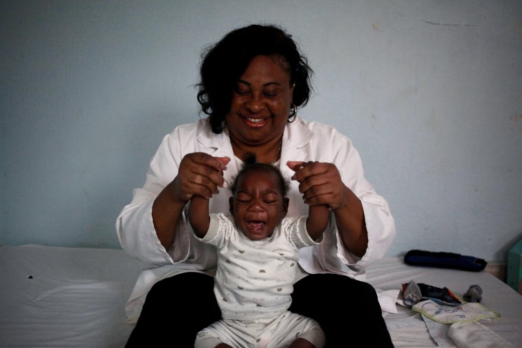 Ten month old Emiliano Cula, who has microcephaly, receives physiotherapy to try and stimulate control over his muscles in Luanda