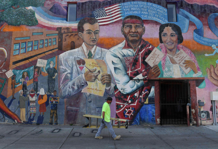 Image: A man walks past a political mural promoting the message for Native American and other minority groups to vote in the upcoming mid-term elections in Albuqurque, New Mexico