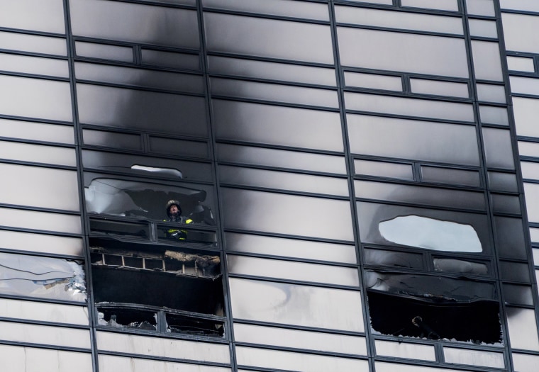 Image: A firefighter looks out from the window of a damaged apartment in Trump Tower in New York