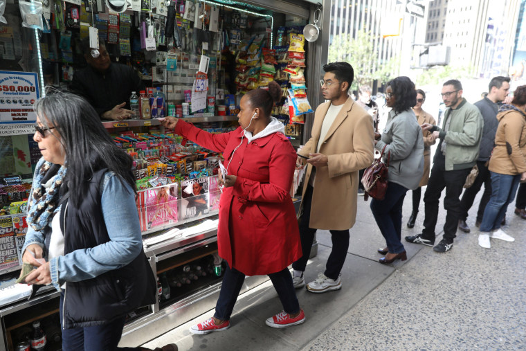 Image: FILE PHOTO: Customers line up to buy Mega Millions tickets at a newsstand in midtown Manhattan in New York
