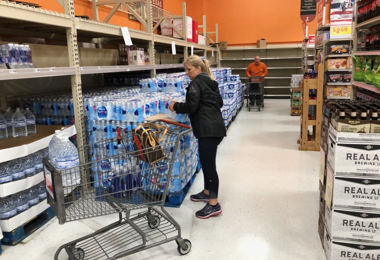 A customer puts waters in her cart at HEB Grocery in Austin, Texas.