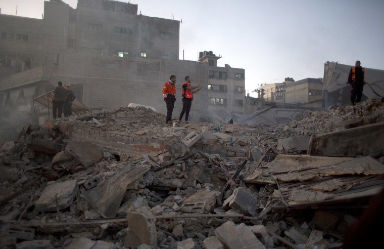 Image: Palestinian firefighters check buildings destroyed by Israeli airstrikes in Gaza City on Saturday