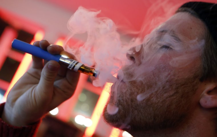 Image: Image: A customer puffs on an e-cigarette at the Henley Vaporium in New York City