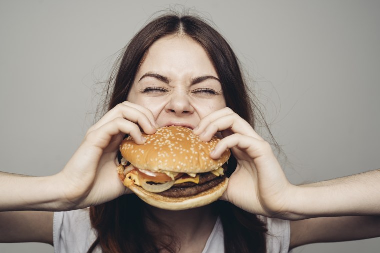 A woman eats a cheeseburger