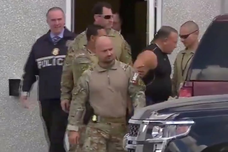 Cesar Sayoc, who was arrested during an investigation into a series of parcel bombs, is escorted from an FBI facility in Miramar