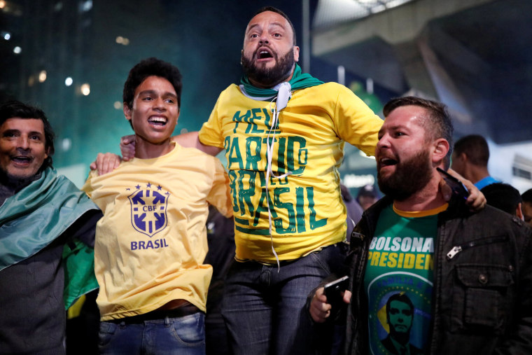Image: Supporters of Jair Bolsonaro, far-right lawmaker and presidential candidate of the Social Liberal Party (PSL), react after polls closed in Sao Paulo