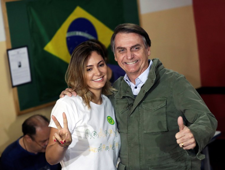 Image: Jair Bolsonaro, far-right lawmaker and presidential candidate of the Social Liberal Party (PSL), and his wife Michelle pose as they arrive to cast their votes