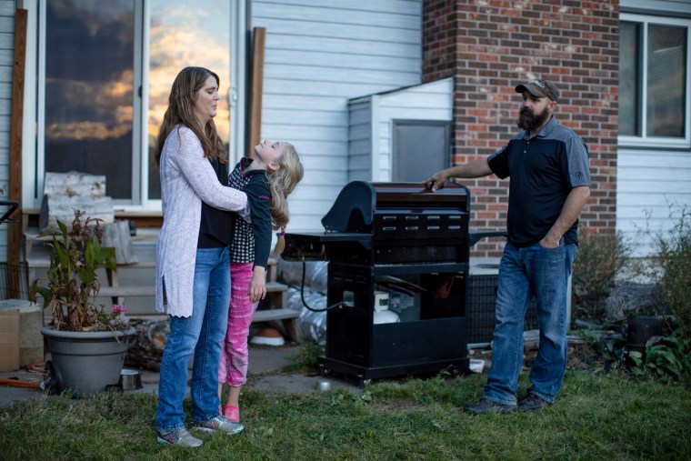 Kristen Kilmer with her daughter and her husband, Chet Kilmer, outside their home.