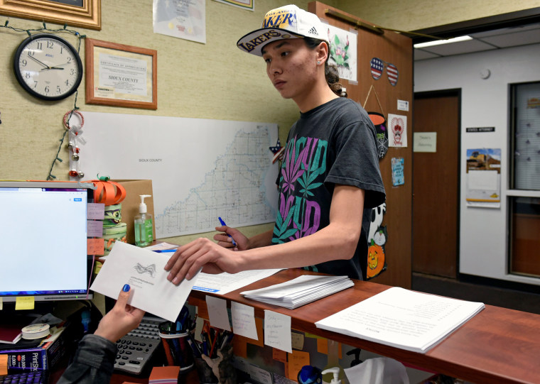 Image: Terrell Elk votes for the first time by delivering his absentee ballot for the 2018 mid-term election to the Sioux County Auditor's office on the Standing Rock Reservation in Fort Yates