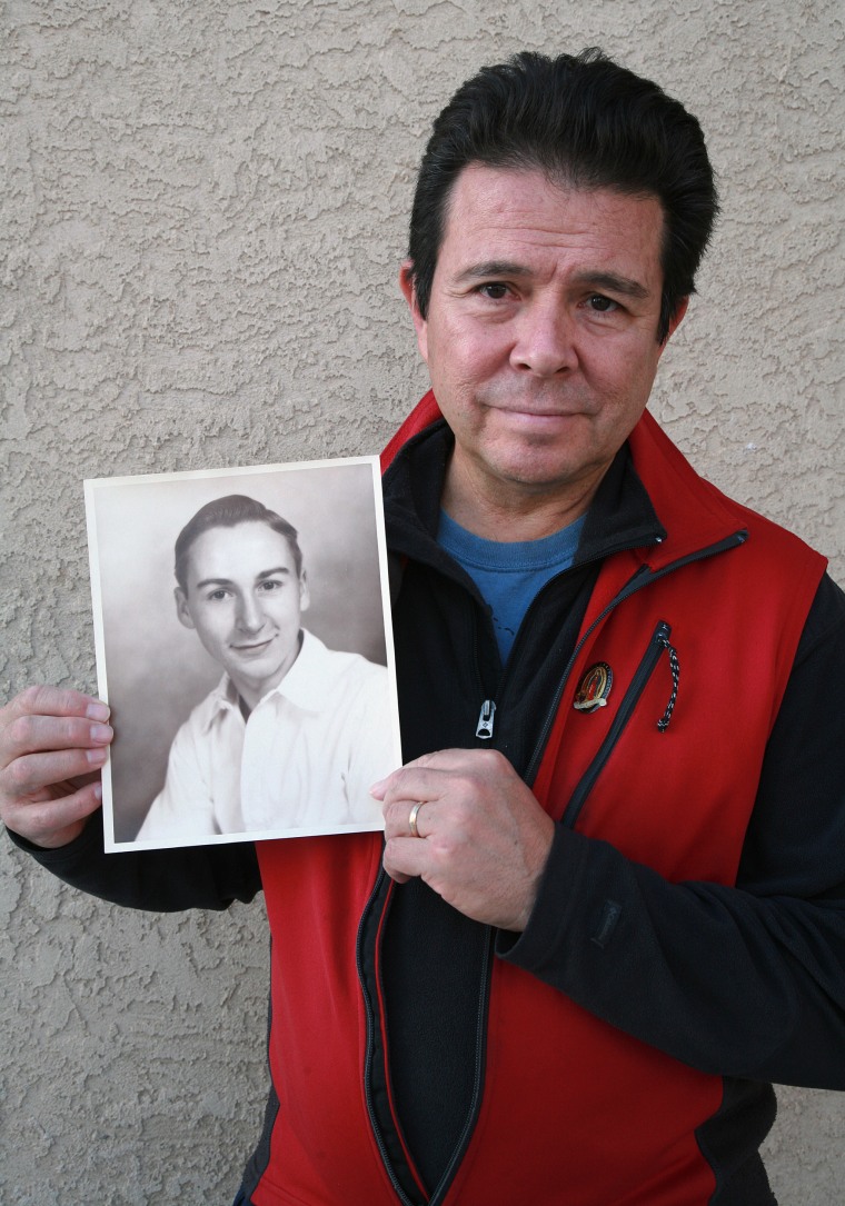 Reuben Ortiz holding a photo of the Rev. Jerome Coyle in Albuquerque, New Mexico on Oct. 30, 2018.