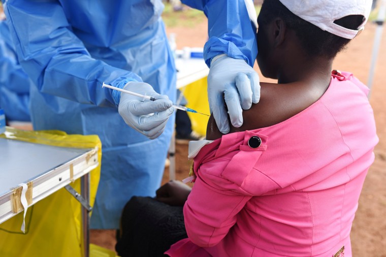 A health worker administers Ebola vaccine to a woman