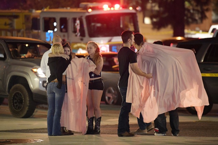 People comfort each other near the scene of Wednesday's mass shooting in Thousand Oaks, California.