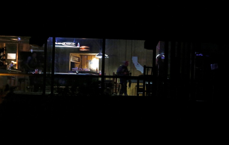 Police guard the inside of the bar
