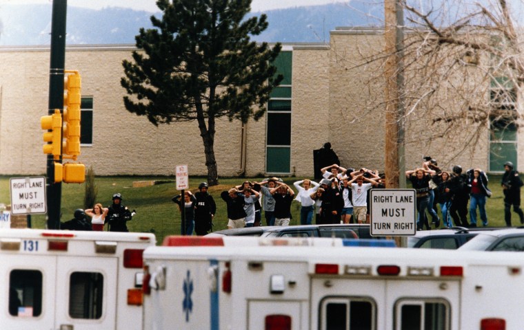 Students are escorted out of Columbine High School by police after a shooting on April 20, 1999.