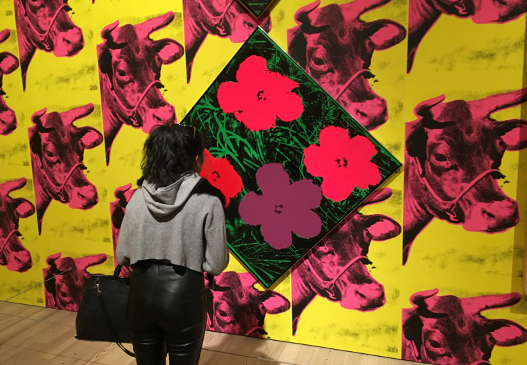 A visitor views Andy Warhol's "Flowers" at a new exhibition at the Whitney Museum of American Art in New York.