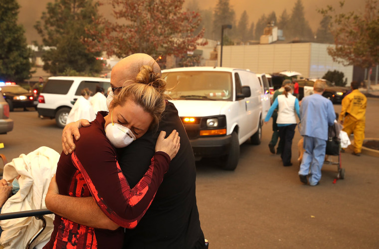 A hospital worker embraces her co-worker as they evacuate patients from the Feather River Hospital in Paradise, California, on Nov. 8, 2018.