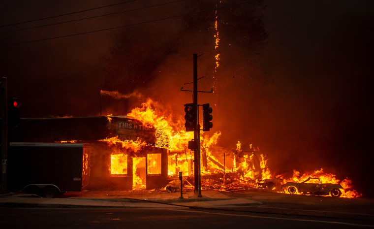 The rapidly spreading fire burns through a store. Gov.-elect Gavin Newsom called a state of emergency in Butte County.