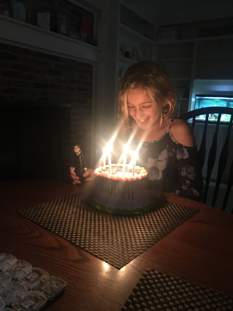 With her Ruth Bader Ginsburg action figure in hand, Sophia Spataro blew out the candles on her Ruth Bader Ginsburg cake.