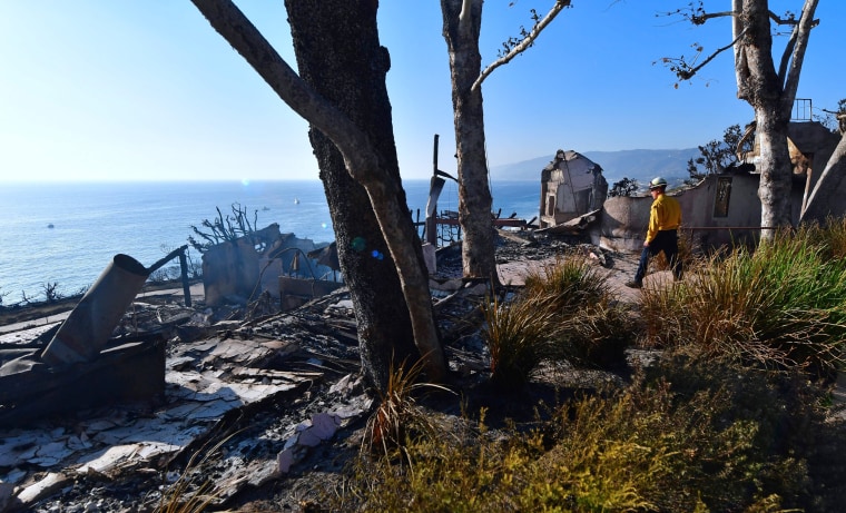 A firefighter inspects the remains of a beachside luxury home along the Pacific Coast Highway community of Point Dume in Malibu on Nov. 11.