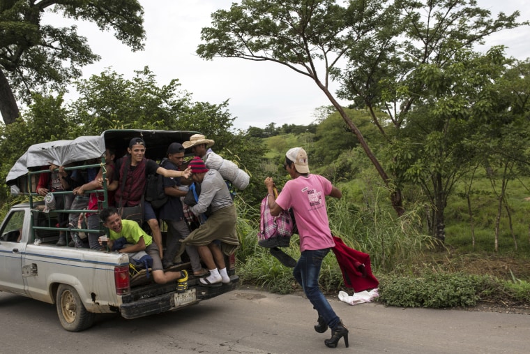 A migrant chases after a pickup truck hoping to hitch a ride to Donaji, Mexico, on Nov. 2, 2018