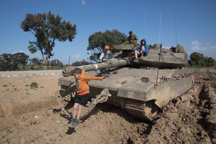 Image: Children from Nirim climb on a tank near the the Gaza Strip