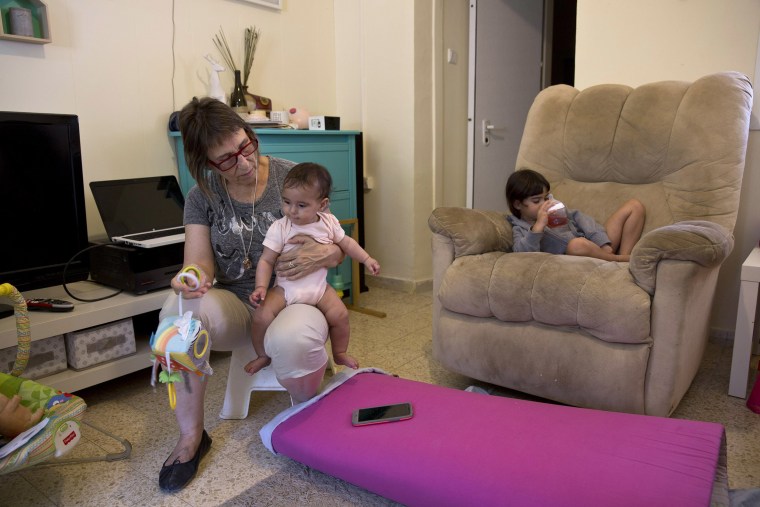 Image: Adele Raemer, 63, with her granddaughters, 6-month-old Raz and and 3-year-old Ziv