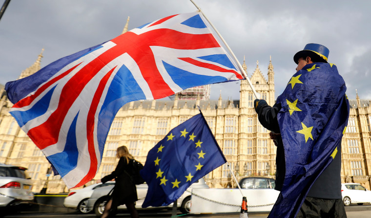 Image: An anti-Brexit demonstrator waves a Union flag alongside a European Union flag outside the Houses of Parliament in London 