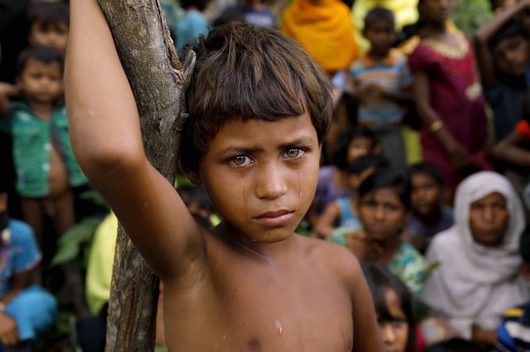 Image: A Rohingya refugee girl stands with newly arrived refugees who fled to Bangladesh from Myanmar