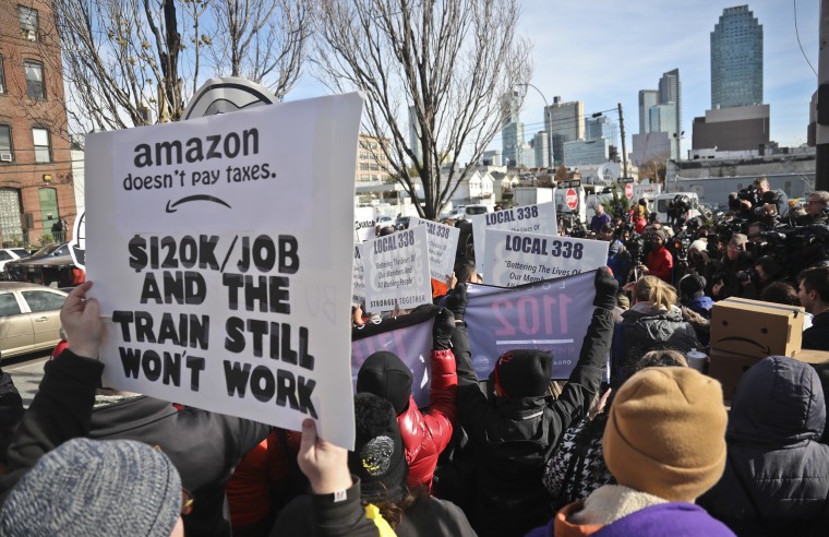 Protesters carry signs during a rally and press conference opposing the Amazon headquarters in Long Island City, New York, on Nov. 14, 2018.