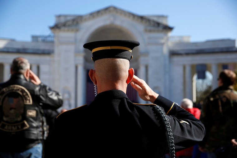 A soldier salutes during ceremonies on Veteran's Day at Arlington National Cemetery in Arlington