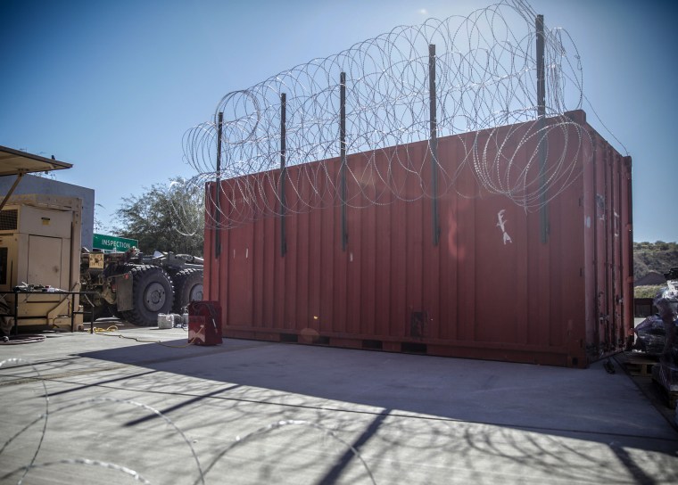 A barricade, made with a shipping container and concertina wire, that could be used to stop migrants attempting to cross the border.